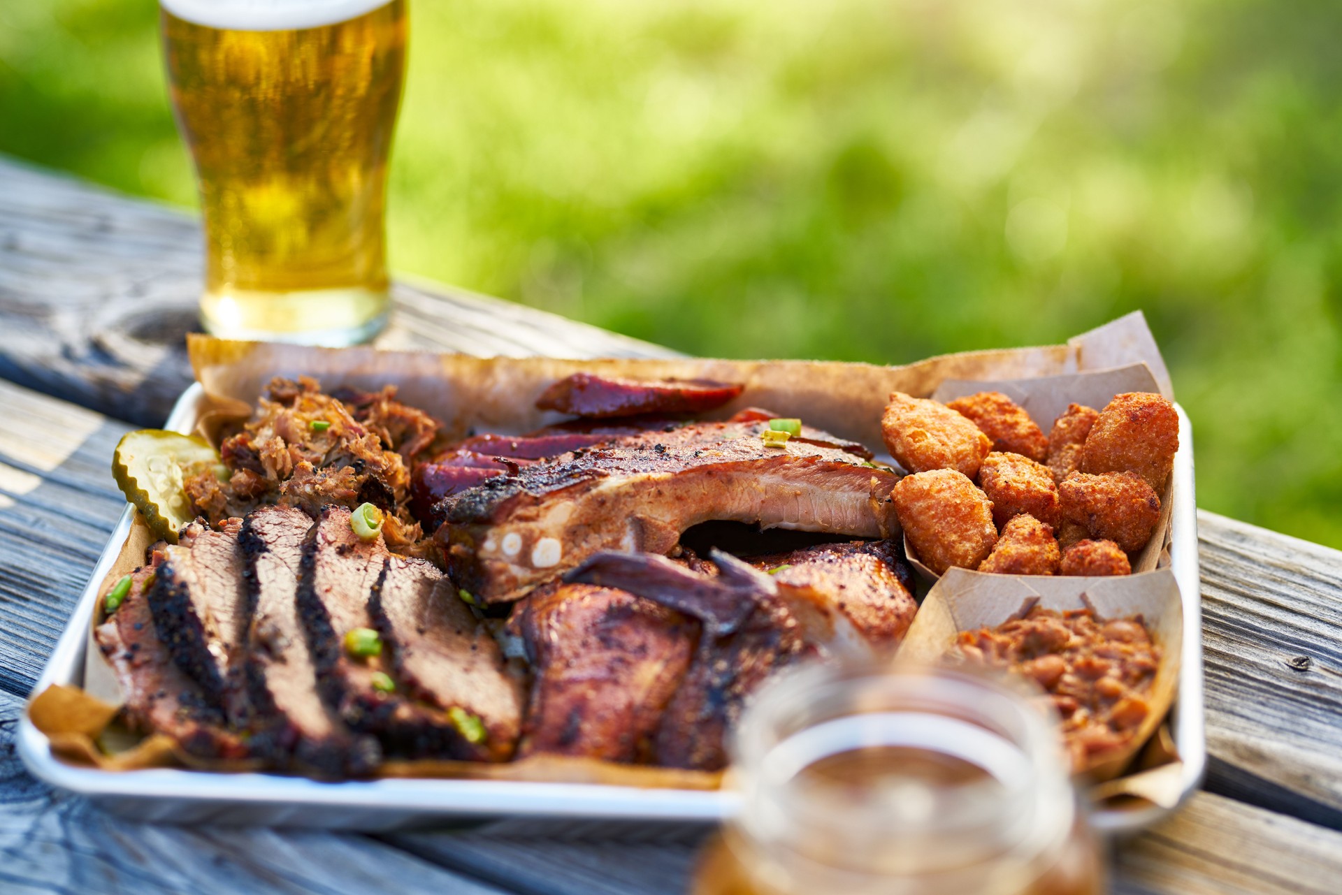 tray of smoked meats texas bbq style outside on picnic table